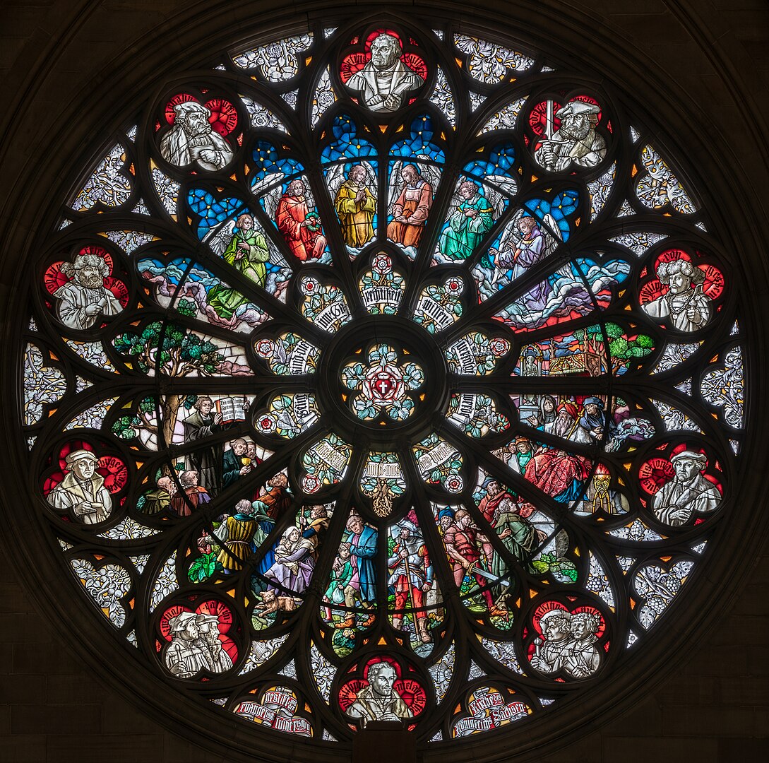 1089px-Speyer_-_Altstadt_-_Gedächtniskirche_der_Protestation_-_linke_Querhausrose_(Märtyrerfenster)_2018.jpeg