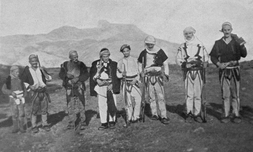 Fotografía de principios del siglo XX de un grupo de hombres de las montañas albanesas con gorros blancos y armas al cinto
