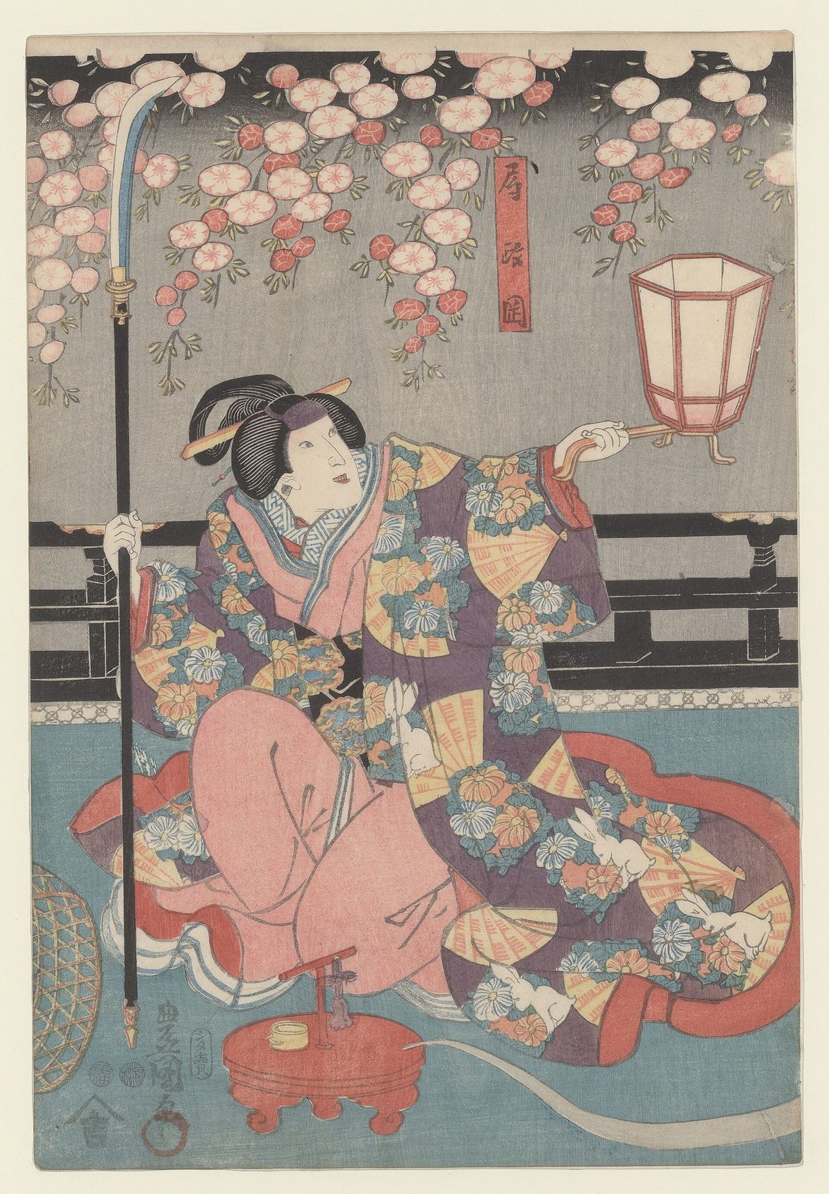 Estampa japonesa en color de un actor de kabuki en papel femenino, con quimono floreado bajo un cerezo y un farol