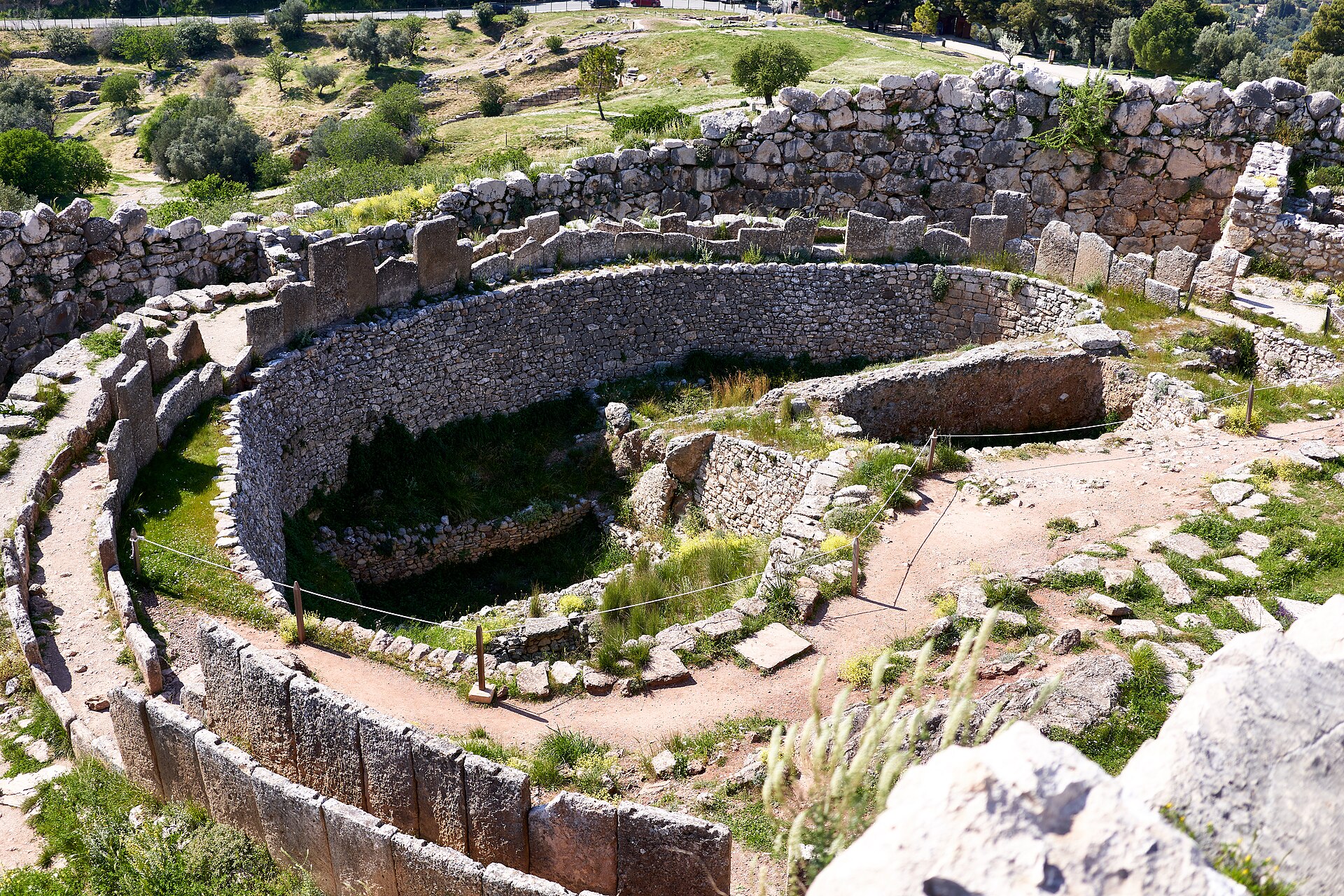 Vista del círculo de tumbas A de Micenas, con los muros circulares de piedra que delimitan los pozos funerarios