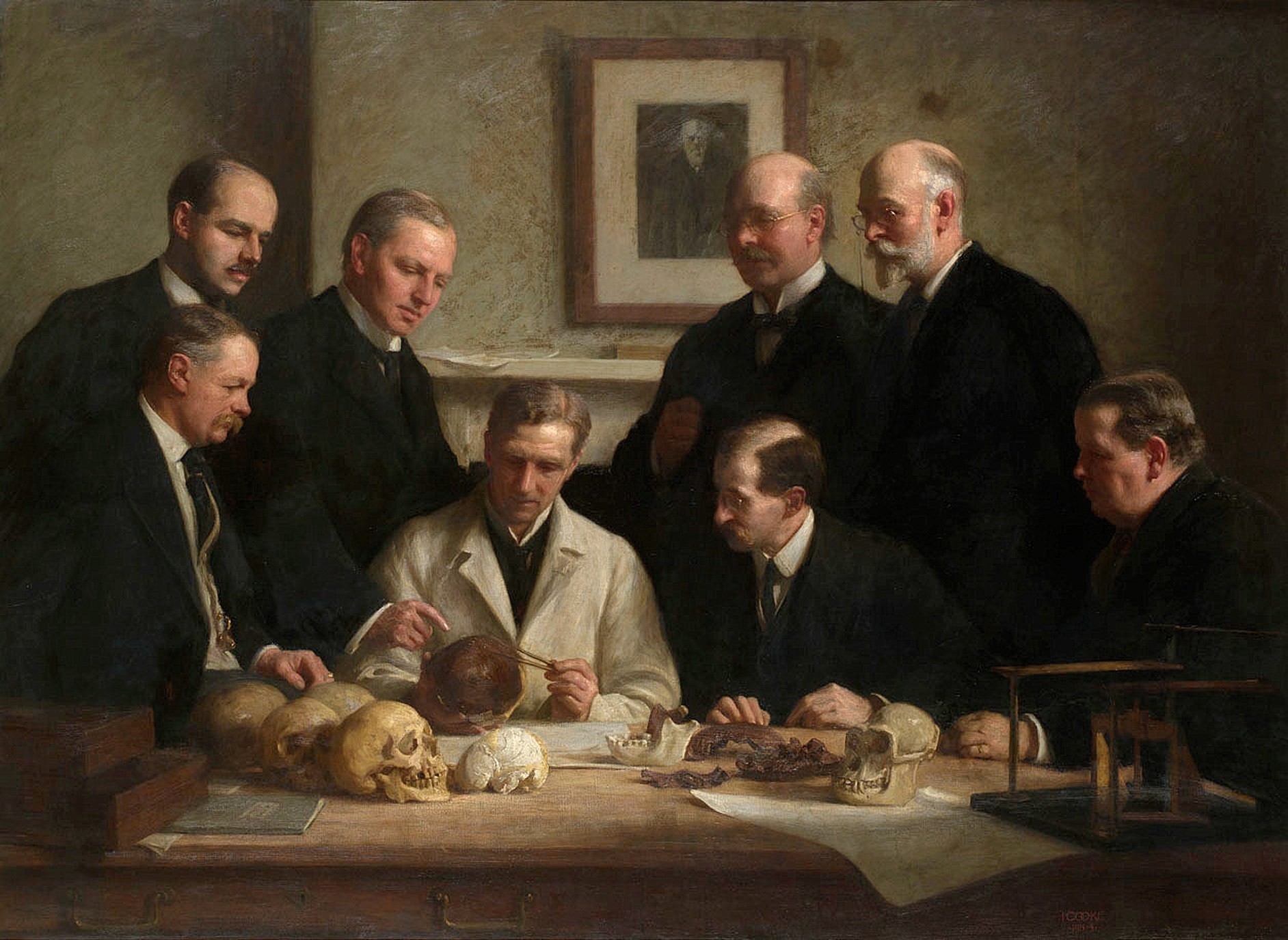 Óleo de 1915 con un grupo de científicos victorianos examinando el cráneo de Piltdown sobre una mesa