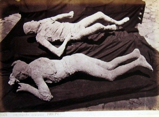 Fotografía antigua en blanco y negro de un vaciado de yeso de una víctima humana de Pompeya, tumbada
