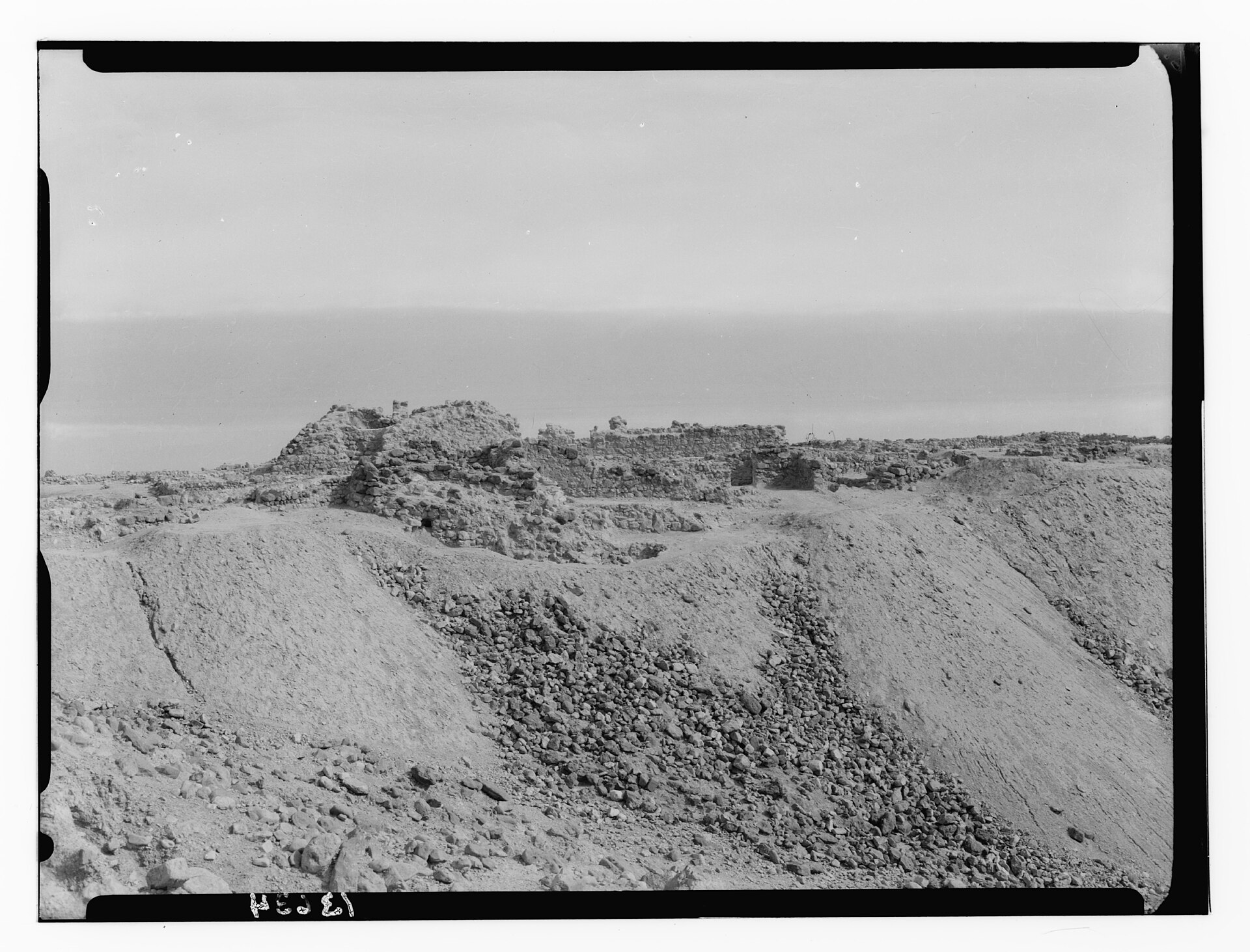 Vista panorámica de ruinas arqueológicas en un paisaje desértico junto al mar Muerto