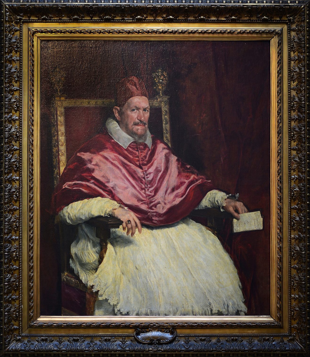 Retrato del papa Inocencio X de Velázquez: el papa sentado, con muceta y birrete rojos, sobre una cortina también roja