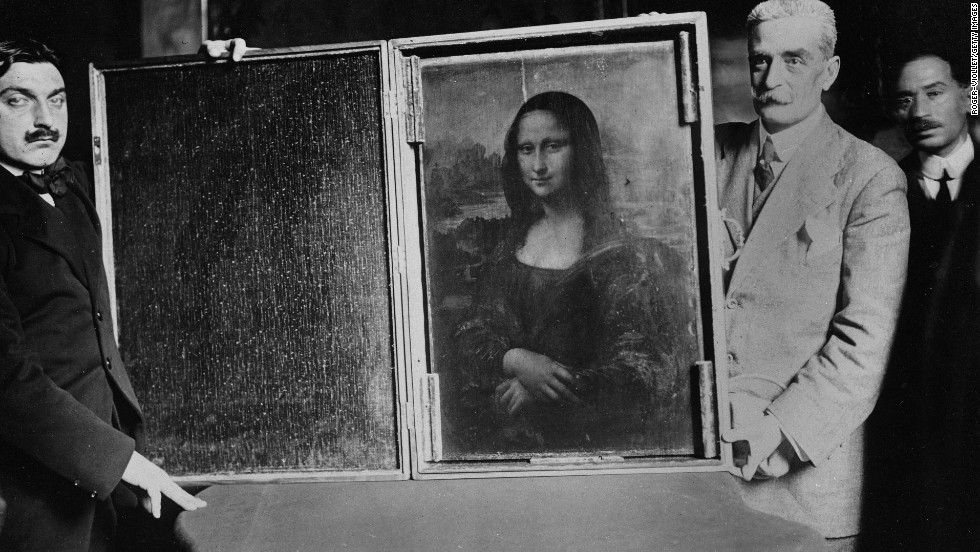 Fotografía de 1914 de varios hombres de traje que sostienen la Gioconda dentro de una caja de madera abierta