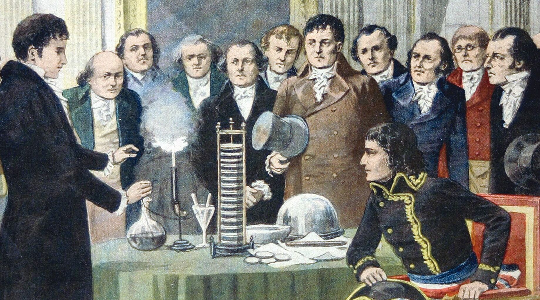 Grabado en color: Volta, de pie, muestra una pila sobre una mesa a Napoleón y a un grupo de académicos