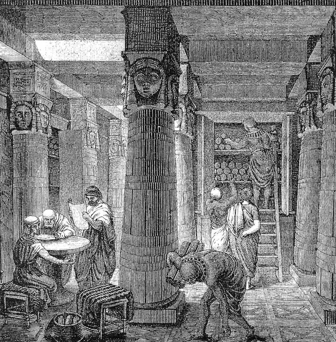 Grabado en blanco y negro de una gran sala con columnas decoradas al estilo egipcio, estanterías con rollos de papiro al fondo y varios hombres con túnicas leyendo y consultando rollos