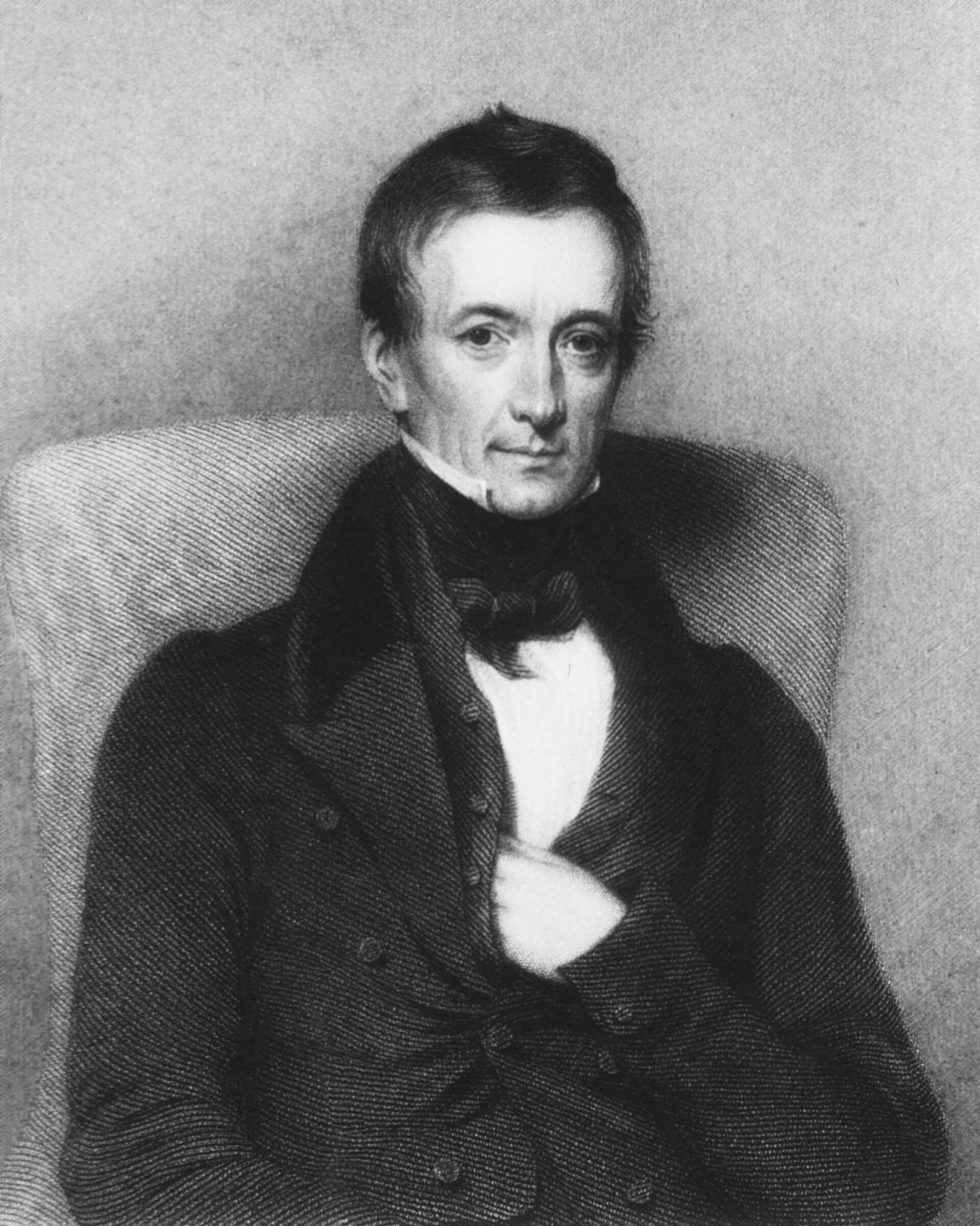 Grabado en blanco y negro de un hombre de mediana edad con el pelo corto y rizado, cuello alto y corbata anudada, sentado de tres cuartos con una mano en el pecho
