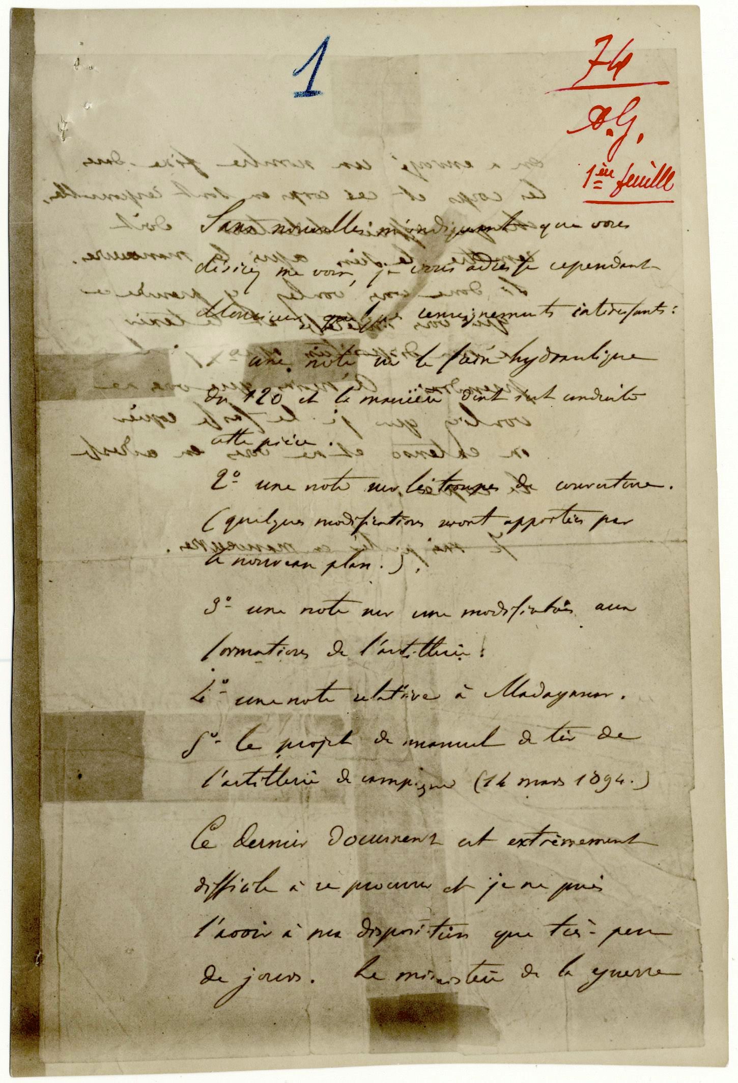 Hoja manuscrita en francés, amarillenta, con marcas de haber sido rota en pedazos y pegada de nuevo, y anotaciones en tinta roja en la esquina superior