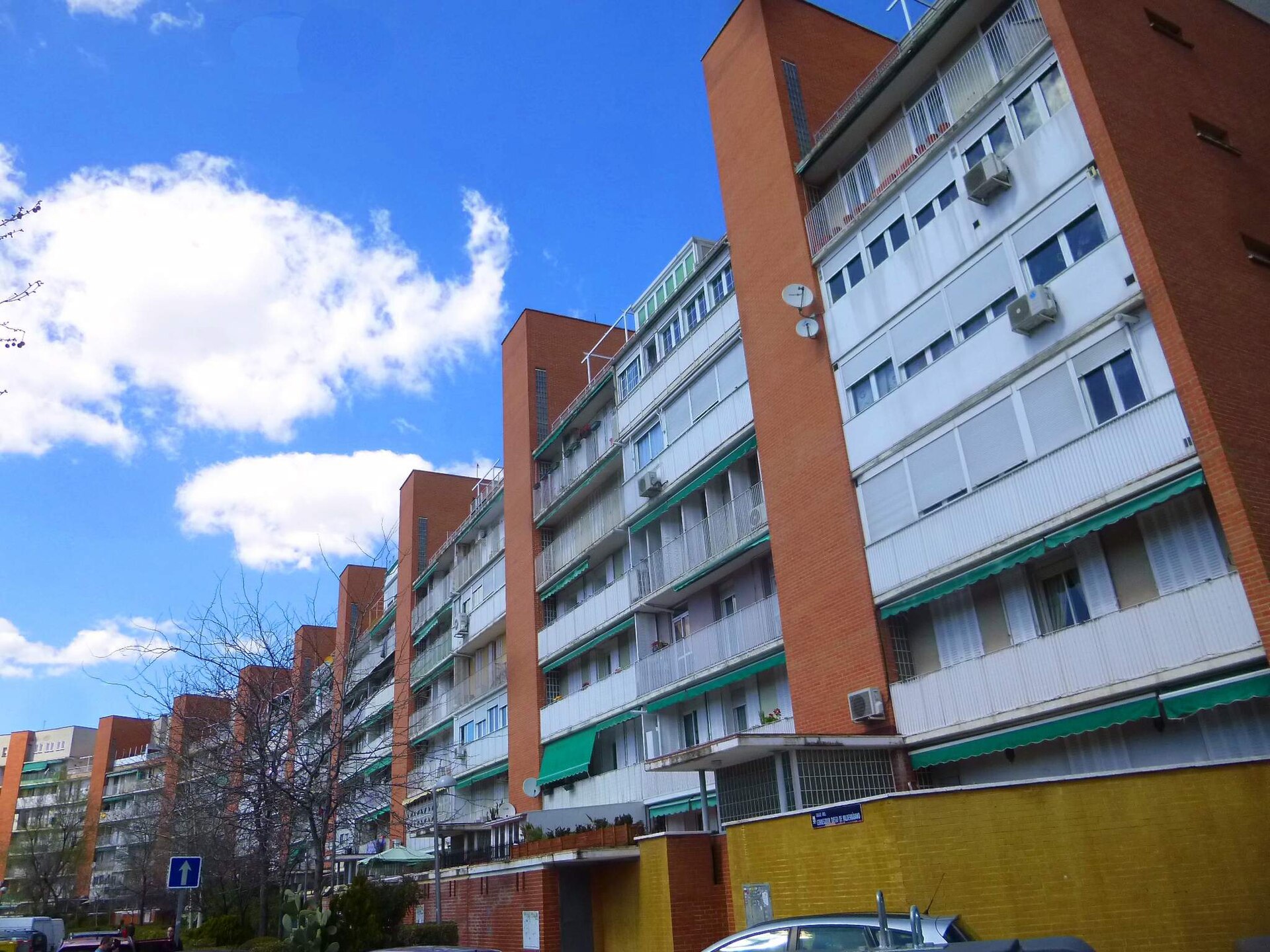 Fotografía de un gran bloque curvo de viviendas de ladrillo, el bloque La Herradura del barrio de Media Legua en Moratalaz, Madrid