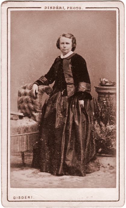 Carte de visite de hacia 1858 con una mujer de pie apoyada en una columna, en vestido oscuro, con el rótulo del estudio Disdéri impreso en la cartulina