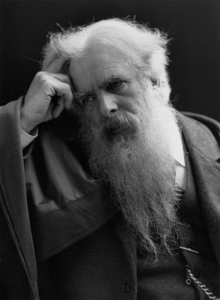 Retrato fotográfico de Eadweard Muybridge, hombre mayor de barba blanca larga, con la mano apoyada en la sien