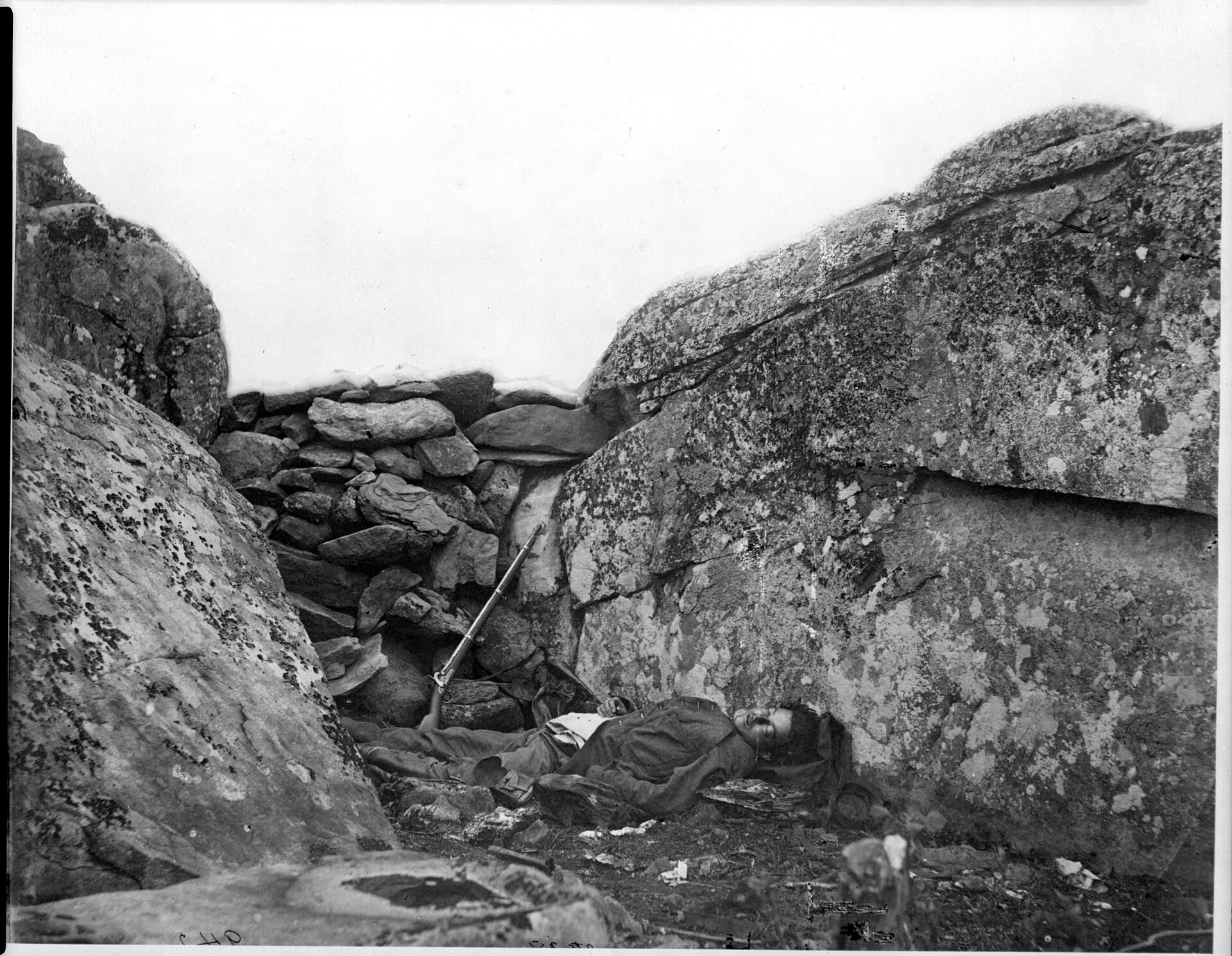 Negativo de 1863 con el mismo soldado muerto entre las dos rocas de Devil's Den, visto desde un ángulo algo distinto