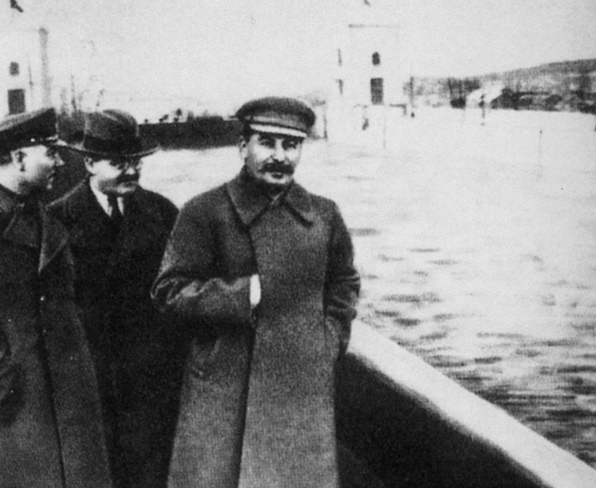 La misma fotografía, con solo tres hombres; donde estaba el cuarto se ve el agua del canal y el pretil