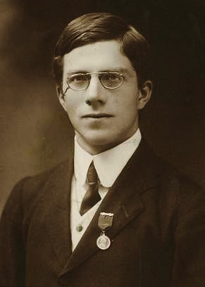 Retrato fotográfico de Ronald Fisher joven, con gafas redondas y traje oscuro