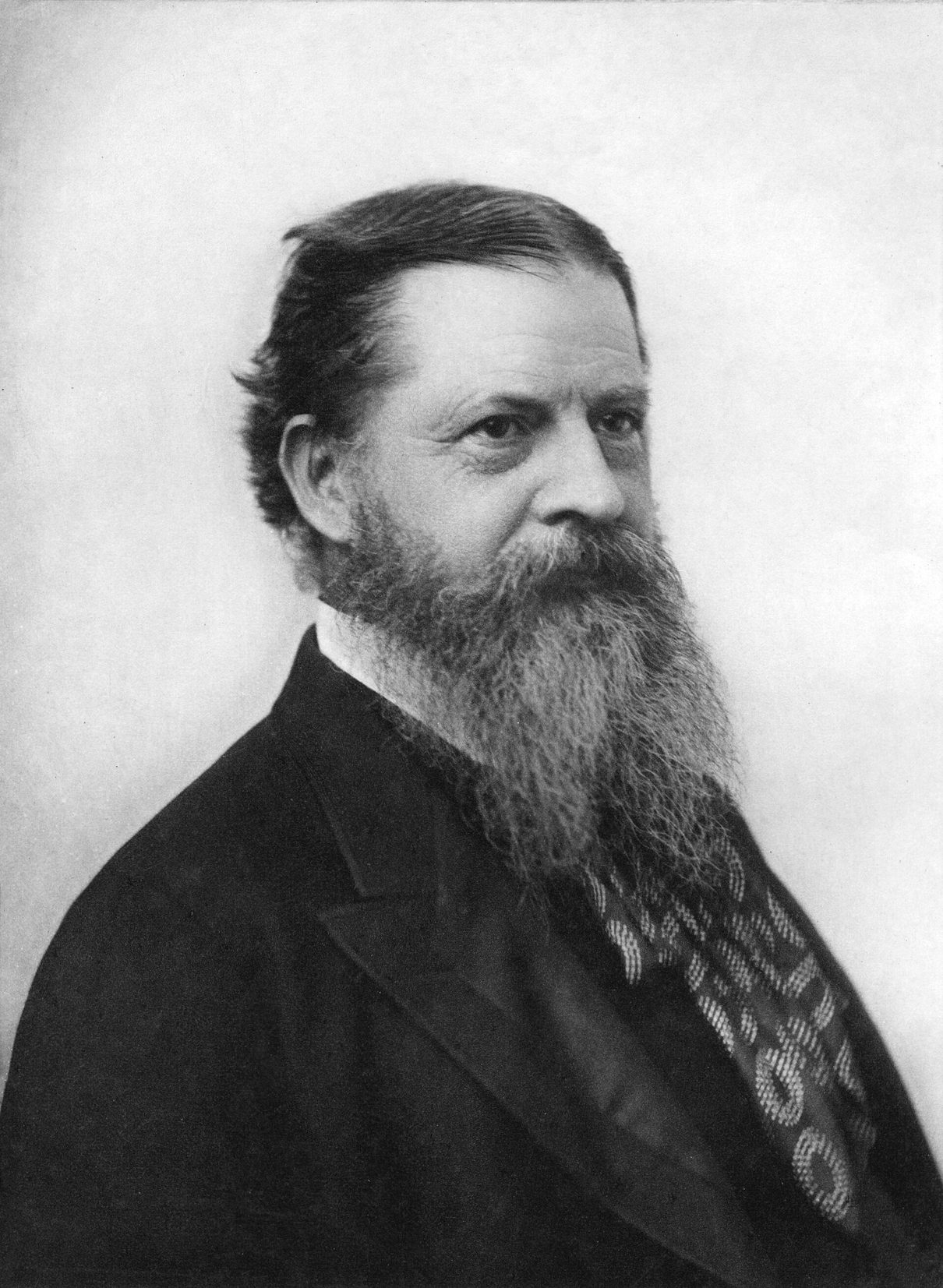 Retrato fotográfico de Charles Sanders Peirce, de perfil tres cuartos, con barba