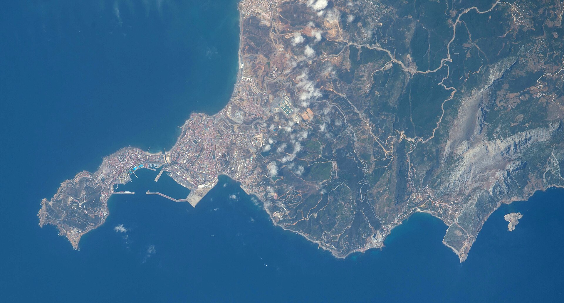Fotografía tomada desde el espacio de la península de Ceuta, su puerto y la costa marroquí vecina, con un islote frente a la costa a la derecha