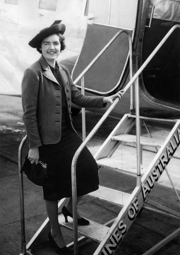 Fotografía en blanco y negro de la azafata Dorothy Webster subiendo la escalerilla de un avión en Queensland, Australia, en 1938