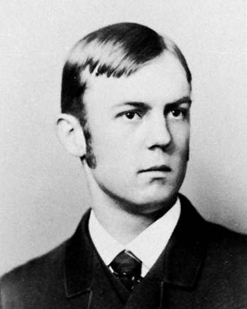 Retrato fotográfico de Charles Horton Cooley, sociólogo estadounidense, con gafas y traje de época