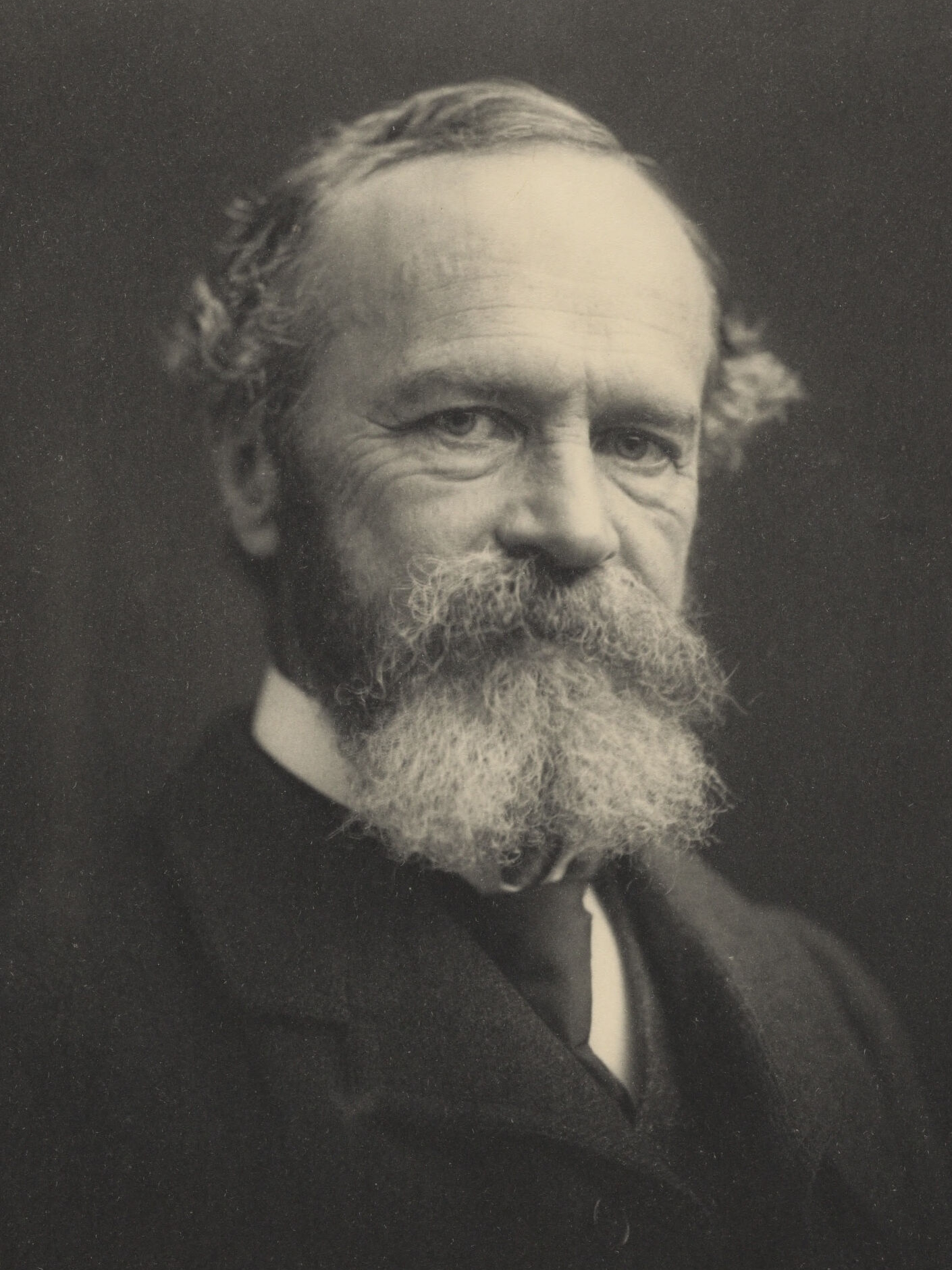 Retrato fotográfico en blanco y negro de William James, filósofo y psicólogo estadounidense, con barba y traje oscuro