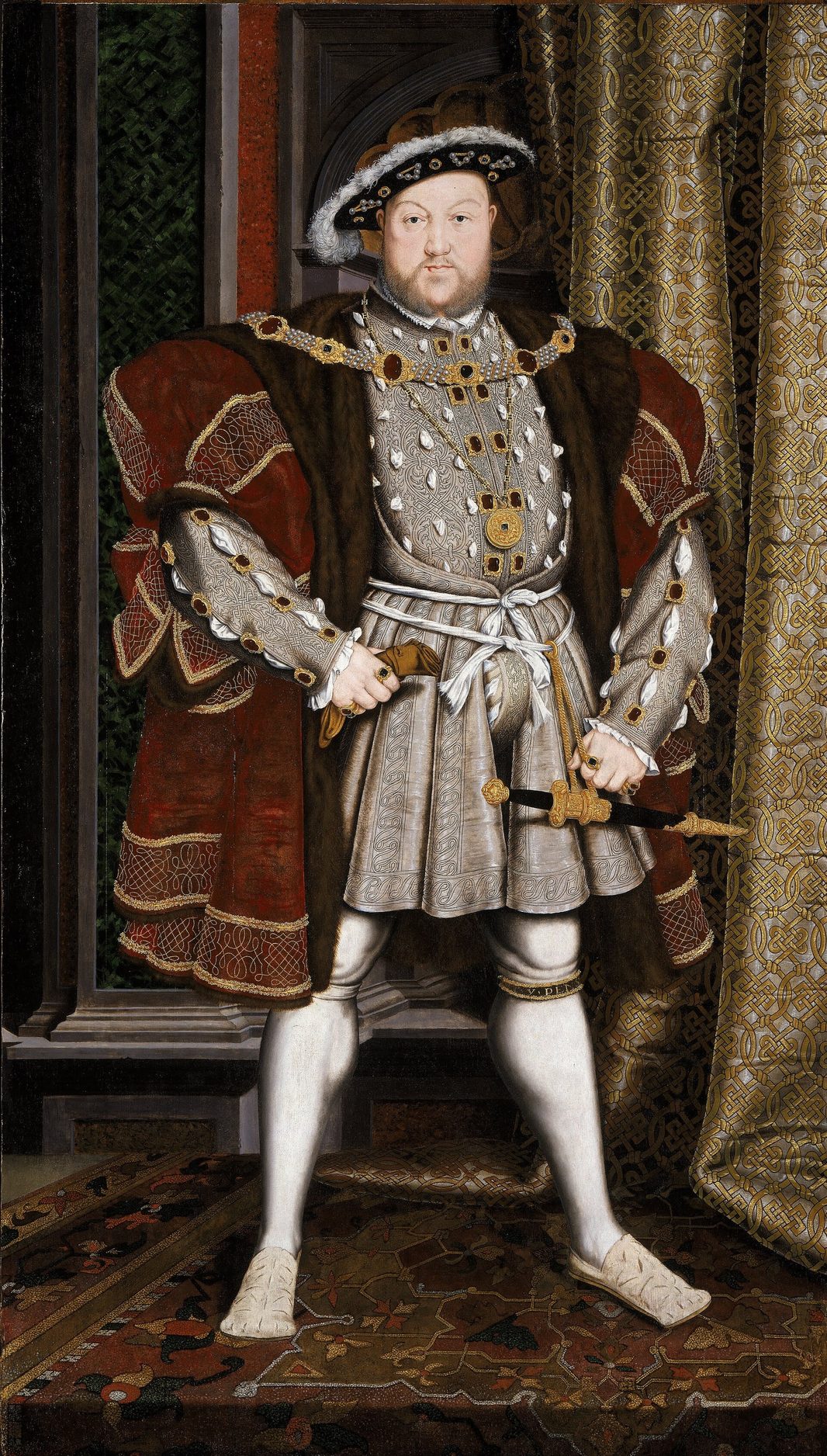 Retrato de cuerpo entero de Enrique VIII de pie, con las piernas abiertas, los brazos separados del cuerpo y ropa ostentosa