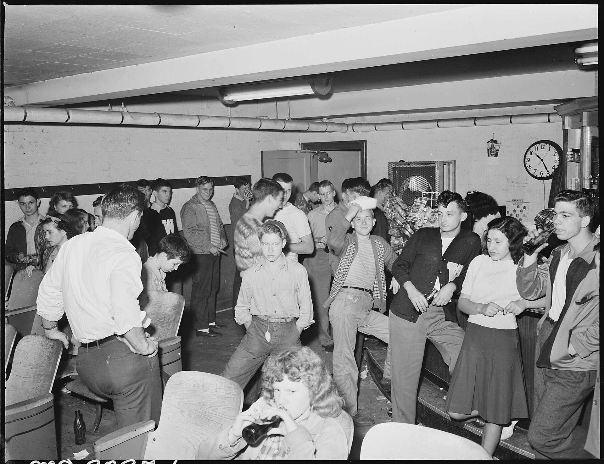 Fotografía de los años cuarenta de una cafetería abarrotada de jóvenes de pie y sentados junto a la barra, después del cine
