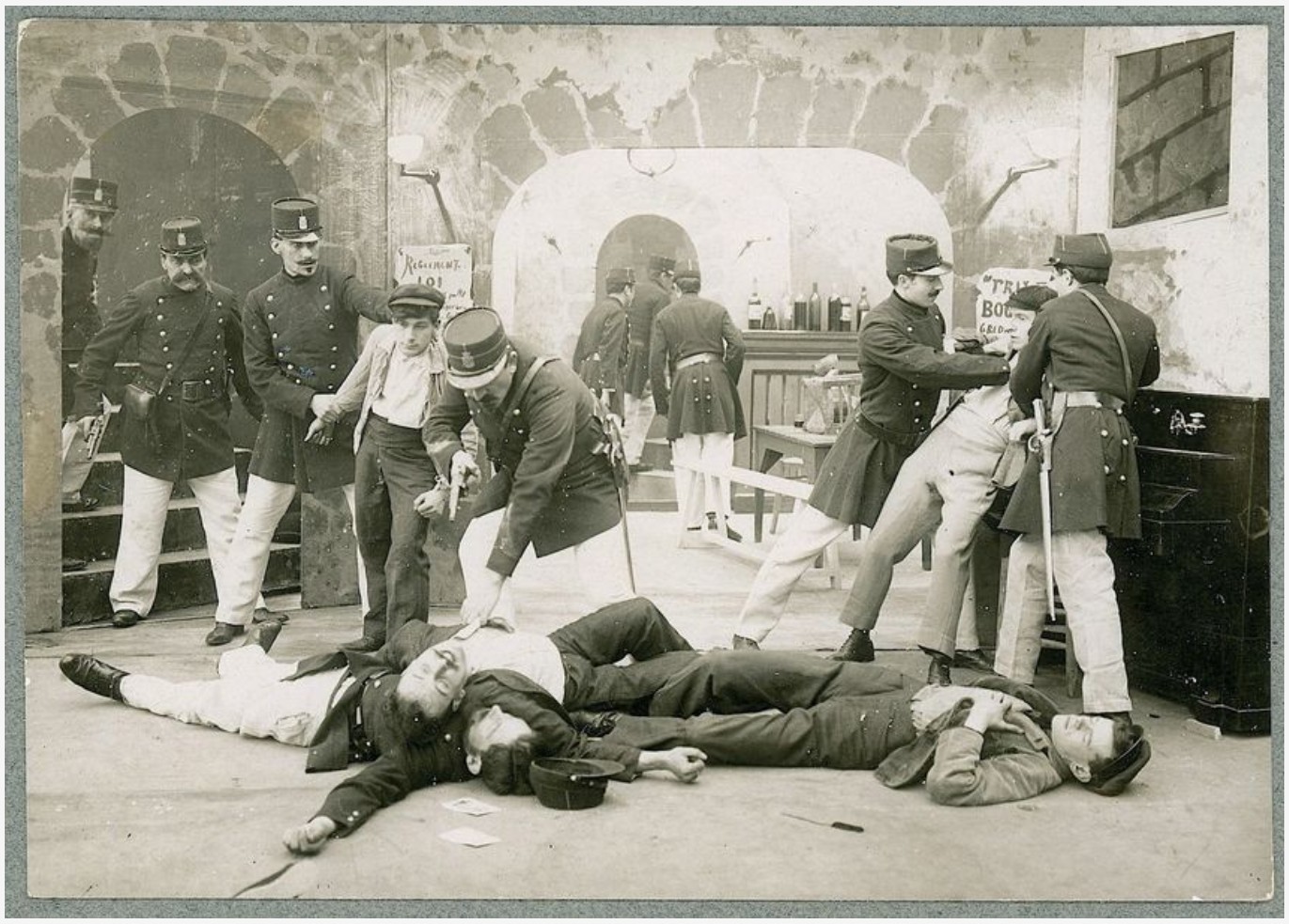 Fotograma de una película de 1905 con varios policías de uniforme rodeando a hombres tendidos en el suelo de una taberna