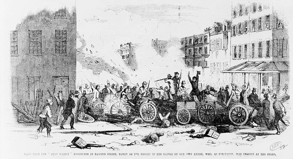 Grabado de 1857 de una barricada callejera improvisada con carros y maderos en una calle estrecha de Nueva York